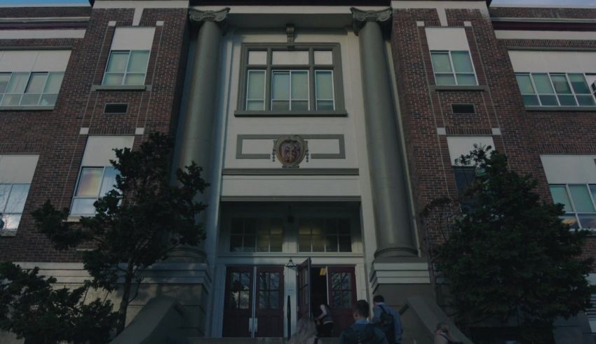 An image of a school building with people walking in front of it.