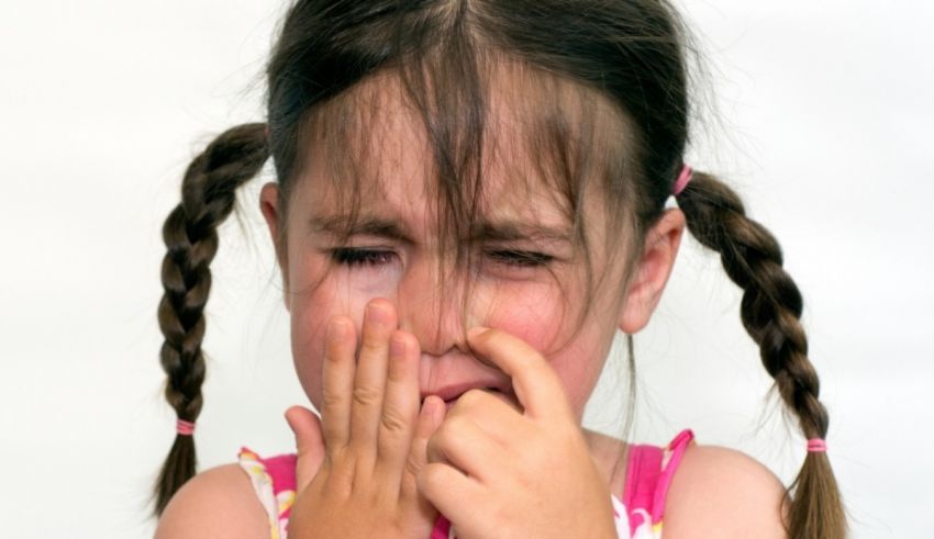 A little girl with her hands on her face.