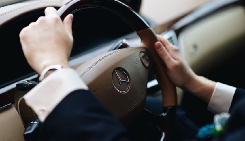 A man in a suit is driving a car.