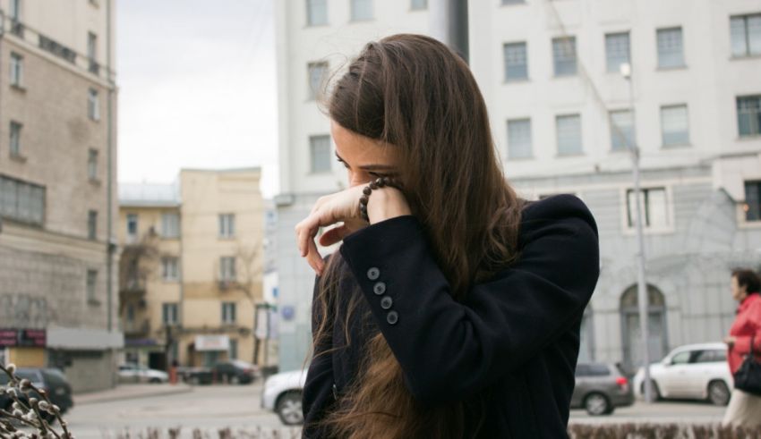 A woman with long hair standing in a city.