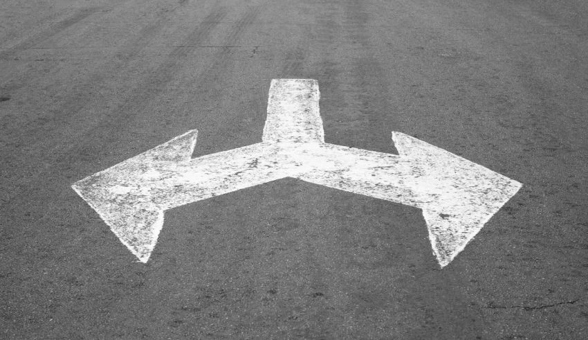 Two arrows painted on the road in black and white.
