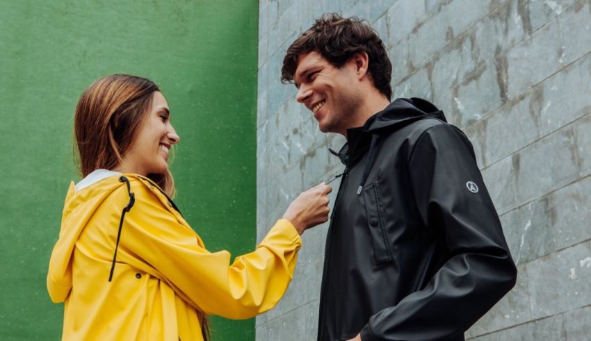 A man and woman in a yellow raincoat talking to each other.
