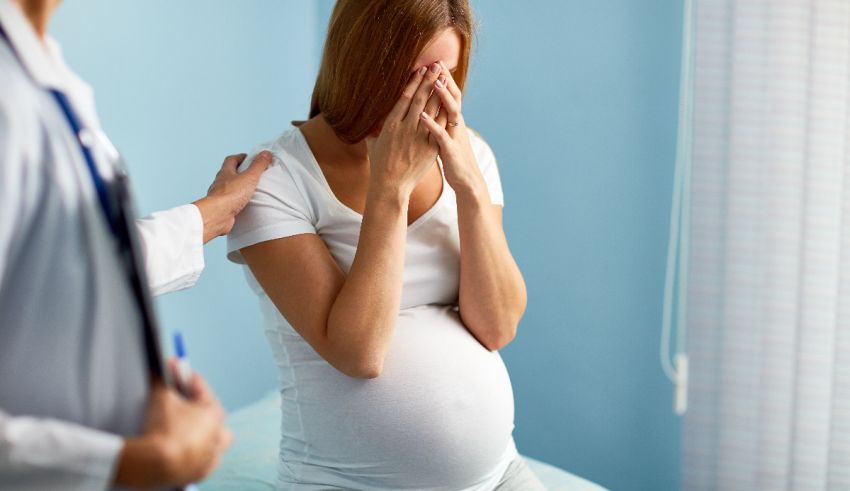 A pregnant woman is being examined by a doctor.