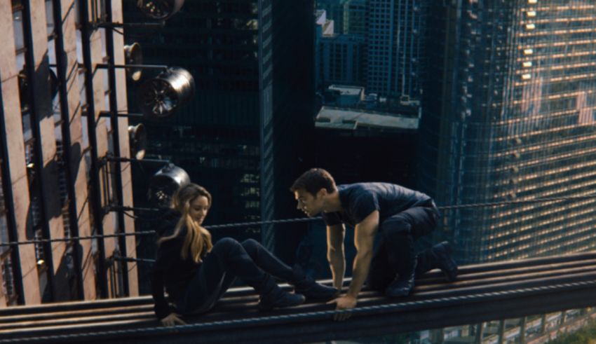 A man and a woman standing on a bridge in a city.