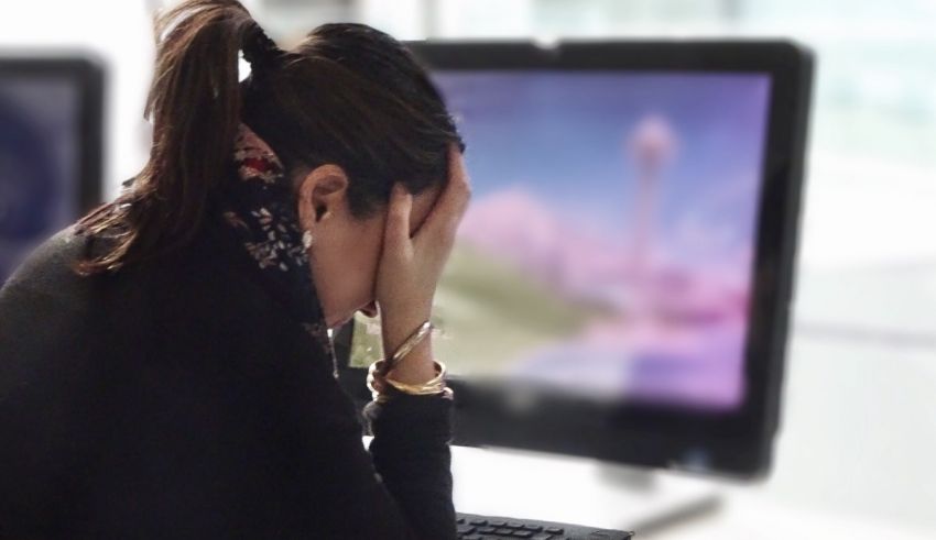 A woman is sitting in front of a computer screen.