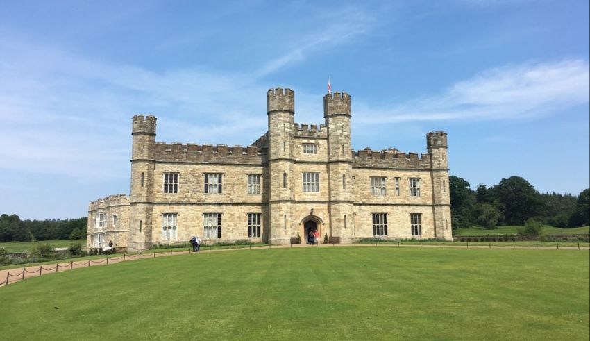 A large castle in the middle of a grassy field.
