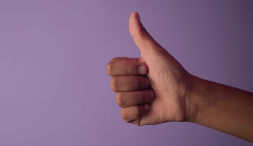 A hand giving a thumbs up on a purple background.