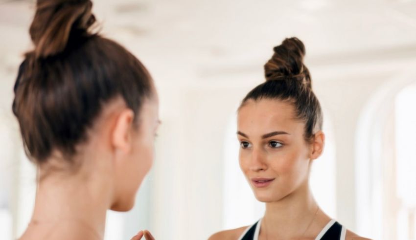 A woman is looking at herself in the mirror.