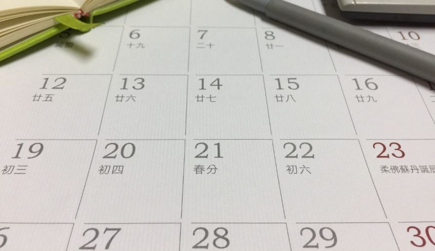 A calendar with a pen and chinese writing on it.