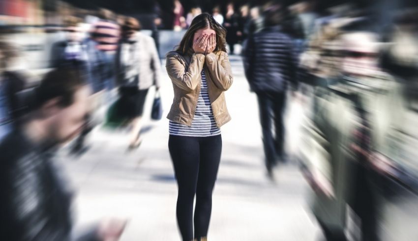 A woman covering her face in front of a crowd of people.
