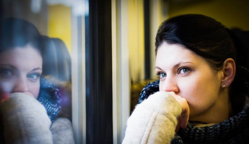 A woman looking out the window of a train.