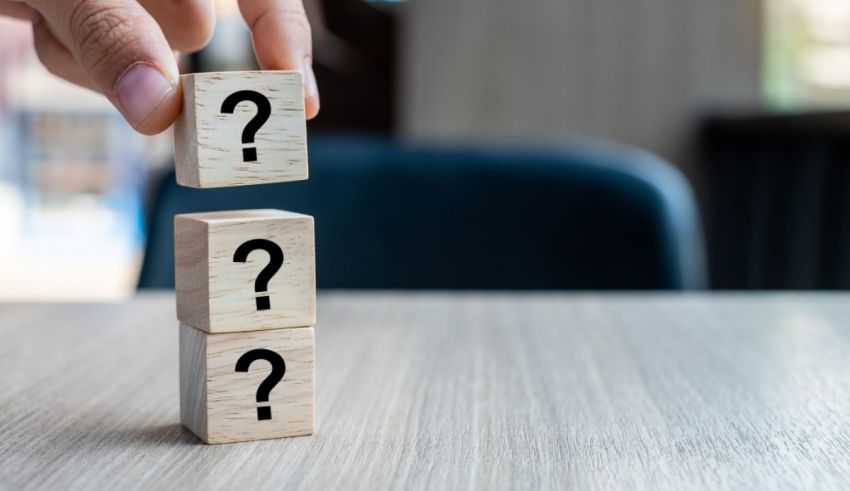 A person holding wooden blocks with question marks on them.