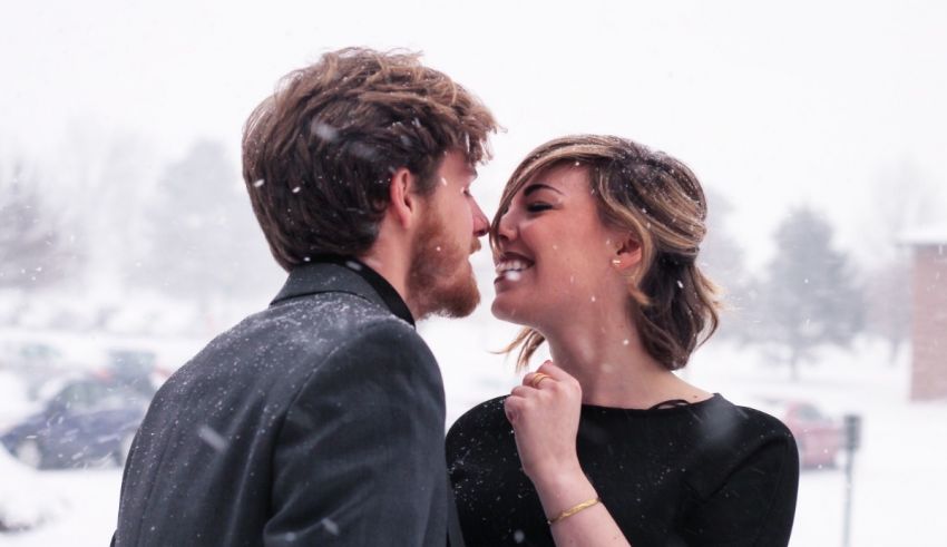 A man and woman kissing in the snow.