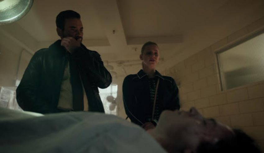 A man and woman are in a hospital room with a dead body.