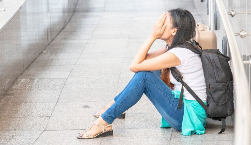 A young woman sitting on the steps of an airport.