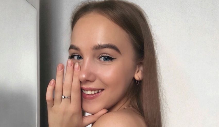 A young woman is posing for a picture with her hand on her face.