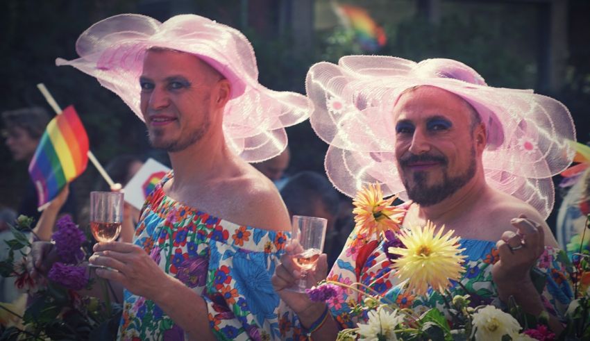 Two men in colorful hats holding flowers.