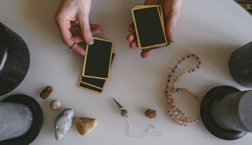 A woman holding a phone and a tarot card on a table.