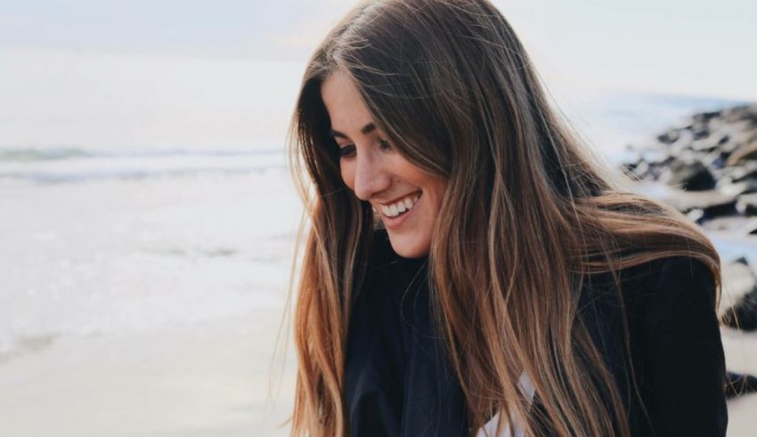 A woman smiling on the beach.