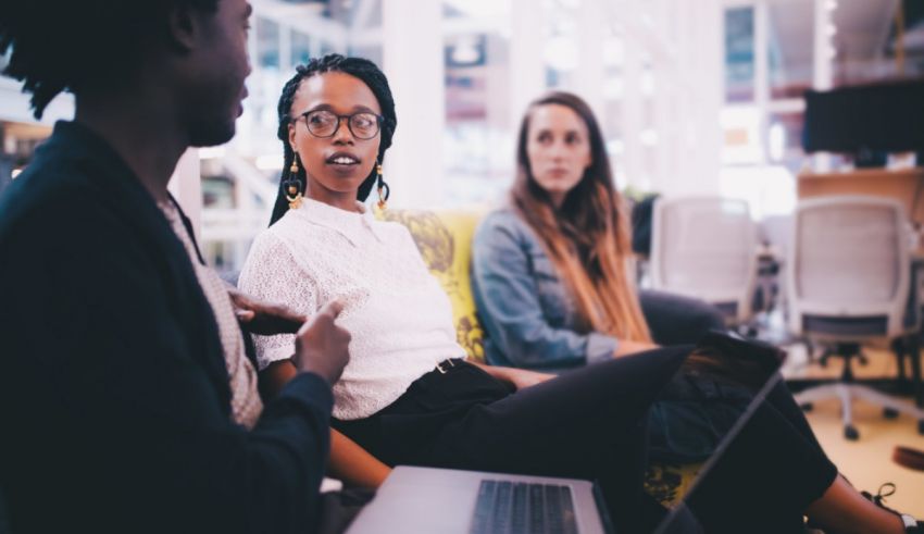 A group of people sitting on a couch in an office.