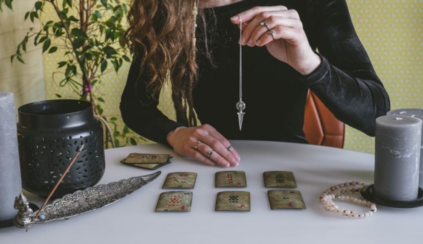 A woman is holding tarot cards on a table.