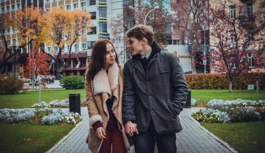 A young couple holding hands in a park.