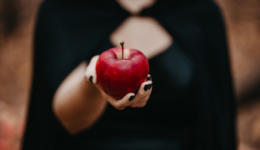 A woman holding a red apple in her hand.