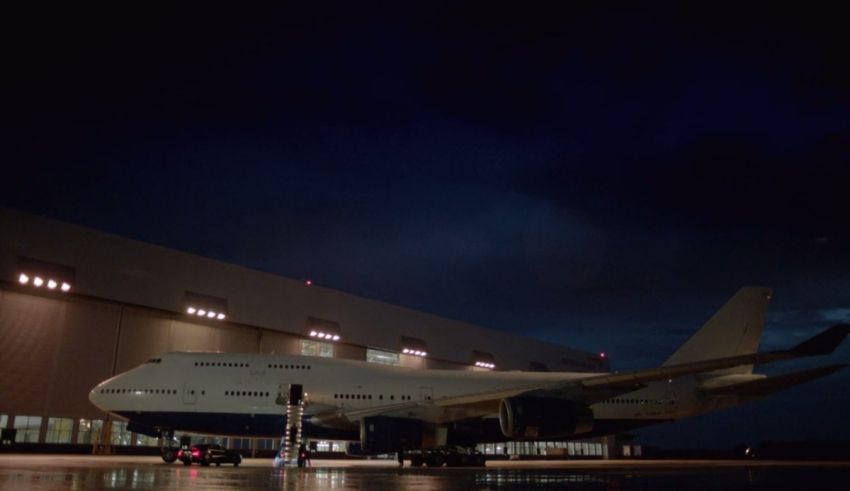 A large airplane parked on the tarmac at night.