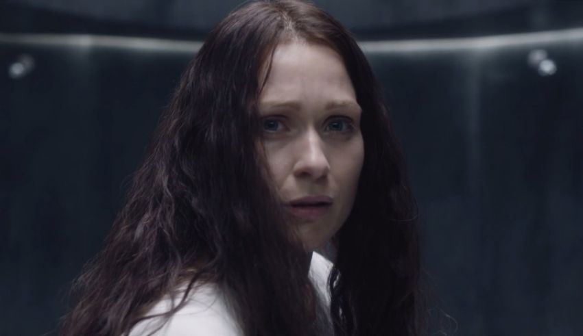 A woman with long hair standing in a dark room.