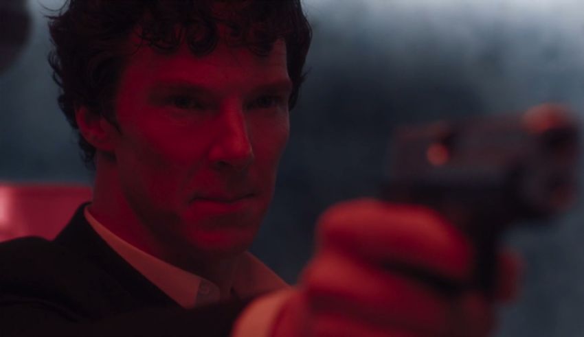 Benedict cumberbatch is holding a gun.