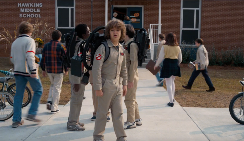 A group of people walking down the street with backpacks.