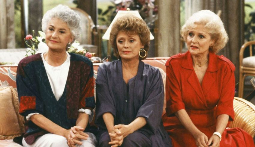 Three golden girls sitting on a couch.