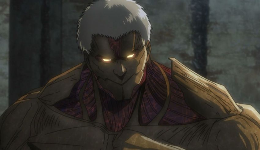 A man with white hair standing in a dark room.