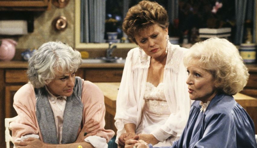 Three older women sitting around a table in a kitchen.