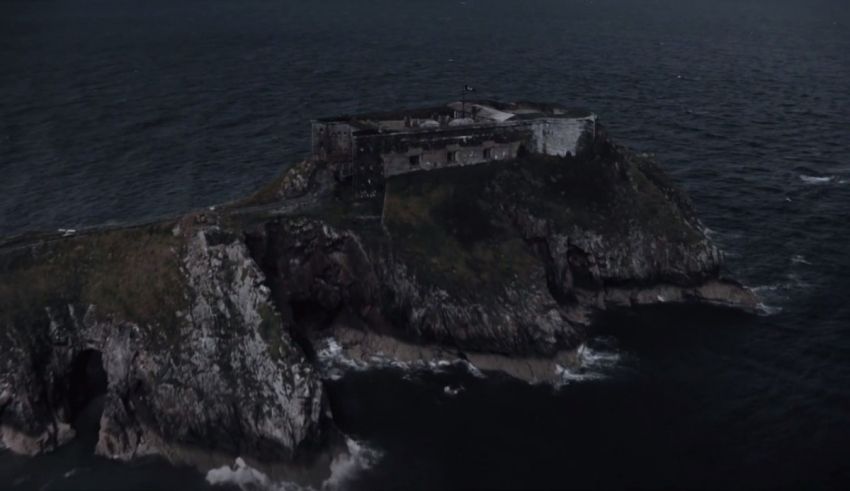 An aerial shot of a castle on top of a rocky island.