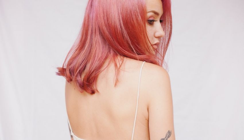 A woman with red hair and tattoos on her back.