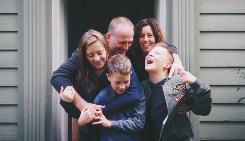 A family is posing for a photo in front of a house.