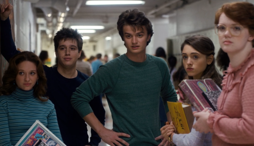 A group of people standing in a hallway with books.