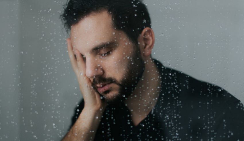 A man in a raincoat is looking at a window.