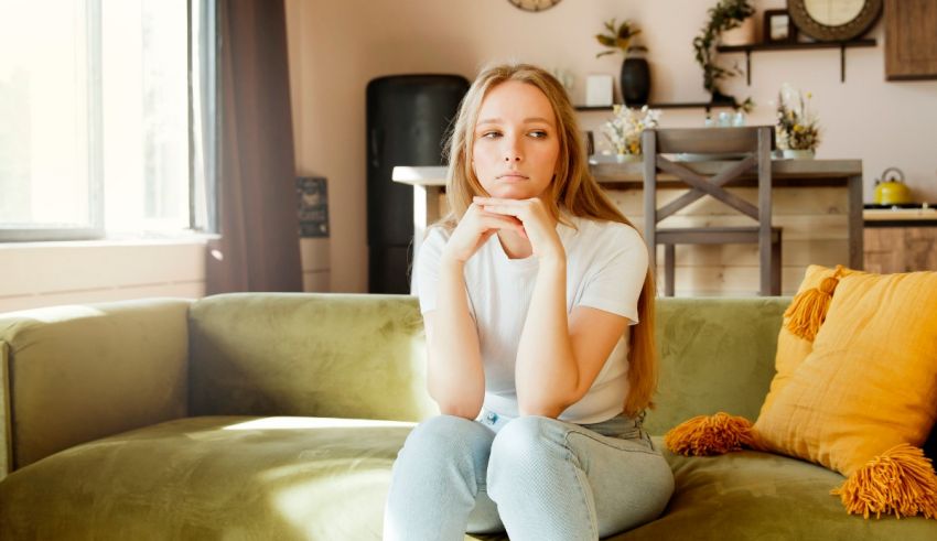 A young woman sitting on a couch in a living room.