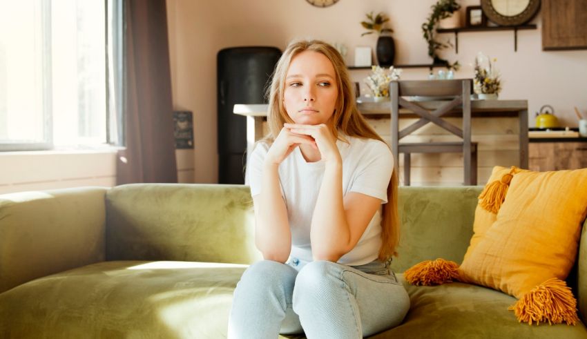 A young woman sitting on a couch in a living room.