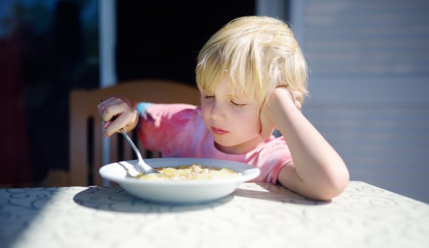 A young boy eating a bowl of cereal.