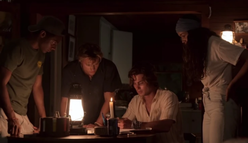 A group of people standing around a table in a dark room.