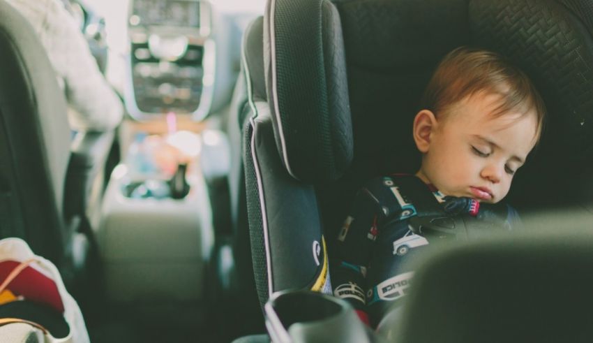 A baby sleeping in a car seat.