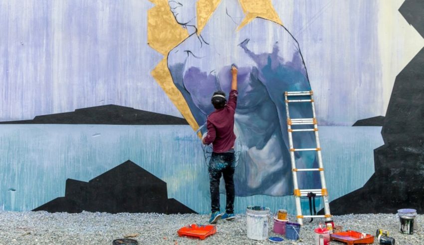 A man painting a mural on a wall.