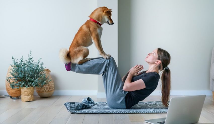 A woman is doing yoga with her dog on a yoga mat.