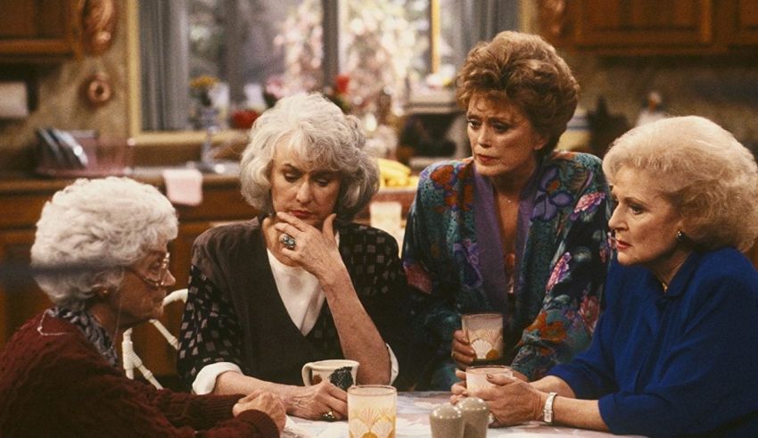 A group of women sitting around a table in a kitchen.