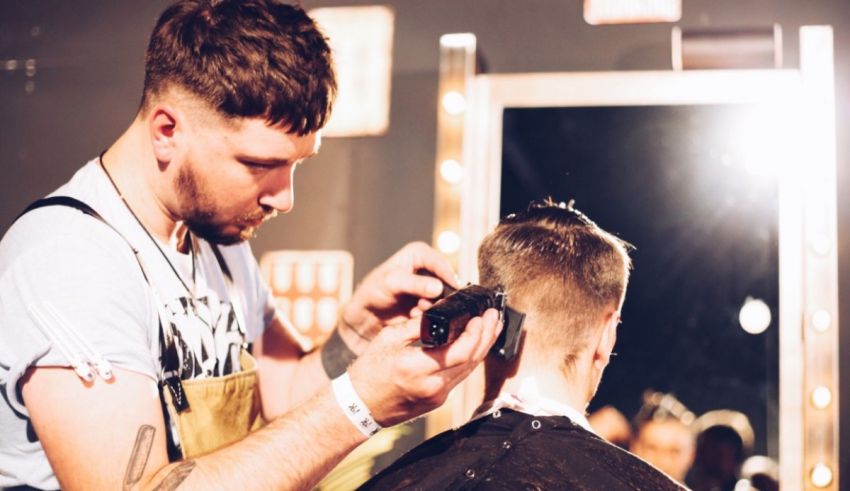 A man getting his hair cut in front of a mirror.