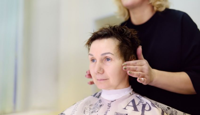 A woman is getting her hair cut in a salon.