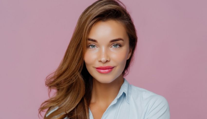 A young woman in a blue shirt is posing for a photo.